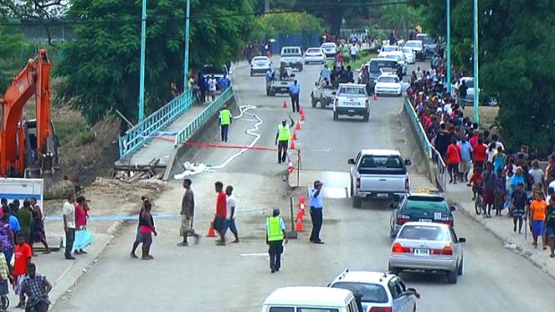 Flood damage: Police officers control traffic passing over a bridge in Honiara amid concern it could collapse.