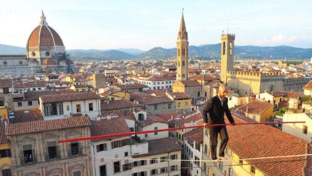 A tightrope walker, Andrea Loreni, balances 40 metres above Piazza della Signoria in Florence, Italy. He crossed from Palazzo Ugaccioni to the Palazzo Vecchio without a safety net.