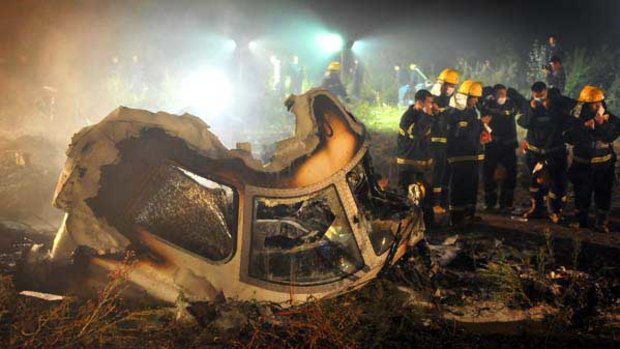 Firefighters work at the crash site in Yichun, north-east China.