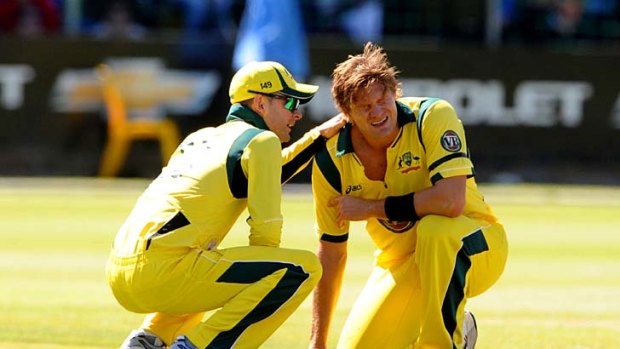 Michael Clarke comforts Shane Watson as he winces in pain after breaking down on Sunday.