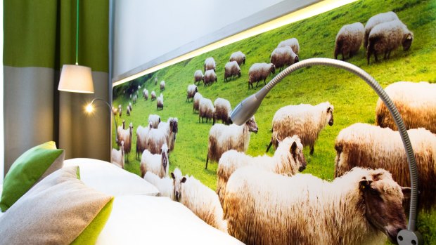 The image of grazing sheep behind the writer's bed in one of the rooms at the Boutique Hotel Stadthalle.