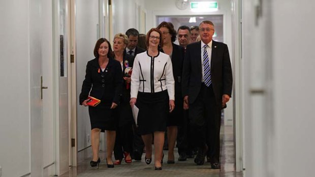 Prime Minister Julia Gillard arrives with her supporters for the caucus meeting.