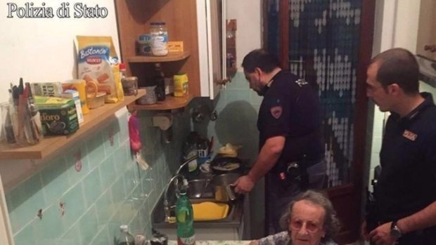 One officer chats to the elderly couple as another washes up. 