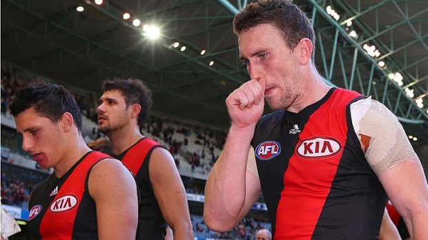 Beaten and bowed: Essendon players after the game.