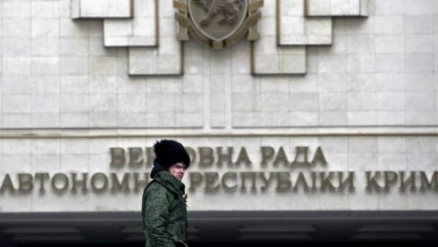 Power shift: A Cossack walks in front of Crimea's regional parliament building in Simferopol.