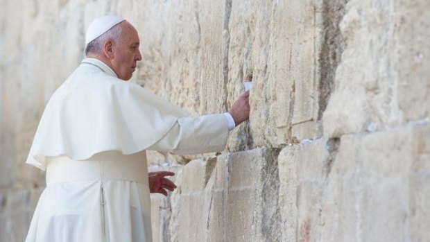 Pope Francis placing a prayer paper at the Western Wall, Judaism's holiest site, in Jerusalem's Old City.