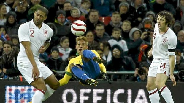 Brazilian striker Neymar attempts an overhead kick past Glen Johnson (L) and Leighton Baines  of England.