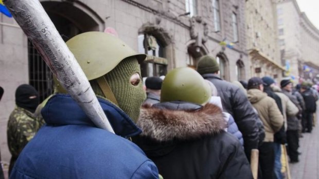 Anti-government protesters leave the city hall in Kiev on Sunday.