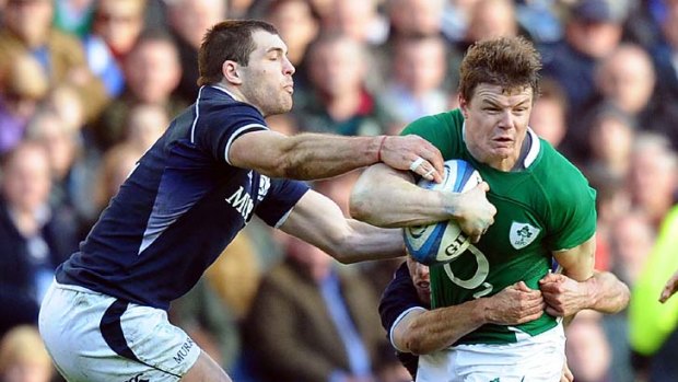 Brian O'Driscoll Ireland is wrapped up by Scotland's defence.