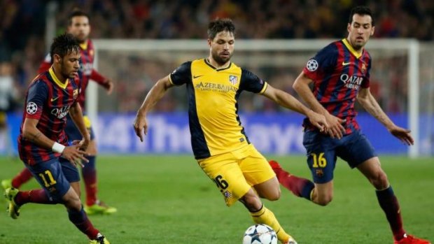 Atletico's Diego, center, drives the ball past Barcelona's Neymar.