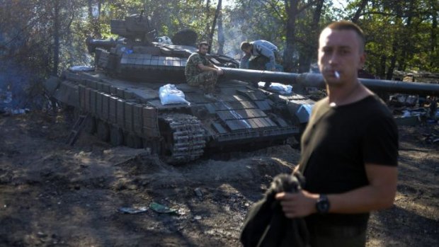 Ukrainian soldiers stand by a tank near Luhansk.