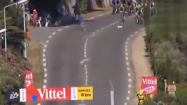 Mad dash ... a dog and a man flee the centre of the road as the Tour de France peloton bears down.