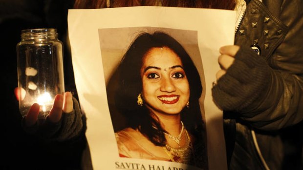 A woman holds a picture of Savita Halappanava at a Belfast vigil. Mrs Halappanava died after being refused an abortion at an Irish hospital.