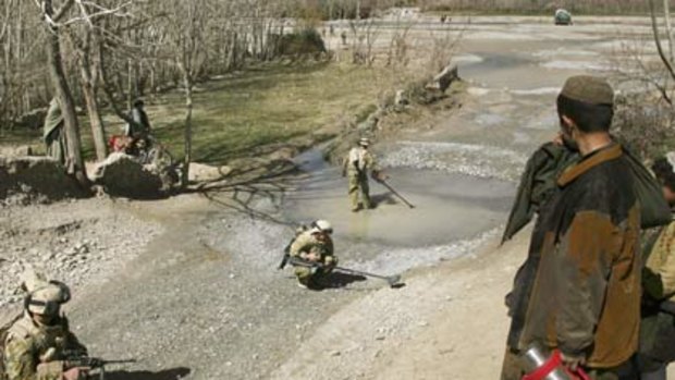 Australian soldiers in Tarin Kowt sweep a creek bed for mines.