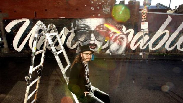 Street artist Rone and one of his latest works, <i>Unstoppable</i>, in Fitzroy. His pieces bob up across Melbourne's inner suburbs.