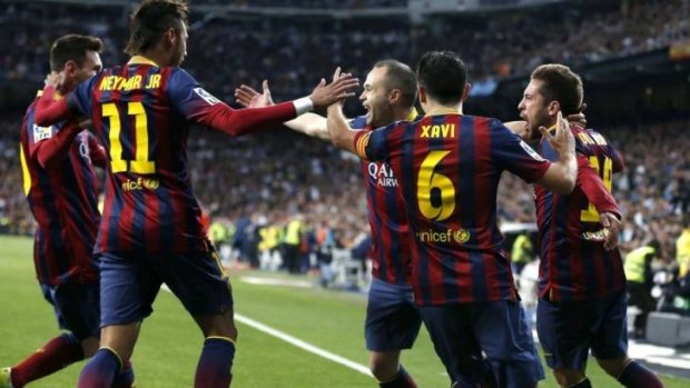 Andres Iniesta celebrates a goal against Real Madrid with his teammates.