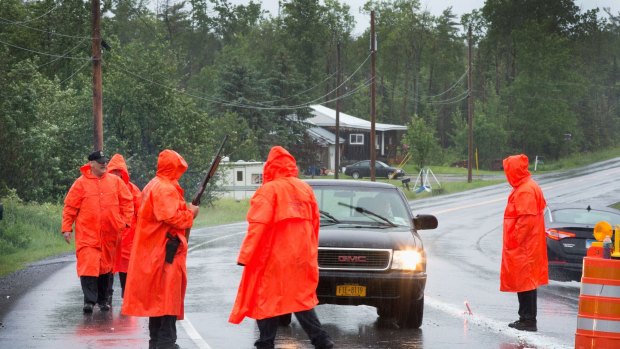  Correction officers search vehicles at a roadblock near a wooded area where they believe escaped convict David Sweat was thought to be hiding near Malone, New York.