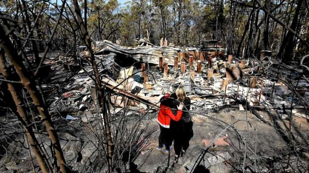 NSW towns count their bushfire losses: Catherine Hubbard and daughter Amy stand in front of the burnt ruins of their home in Winmalee, in the Blue Mountains.