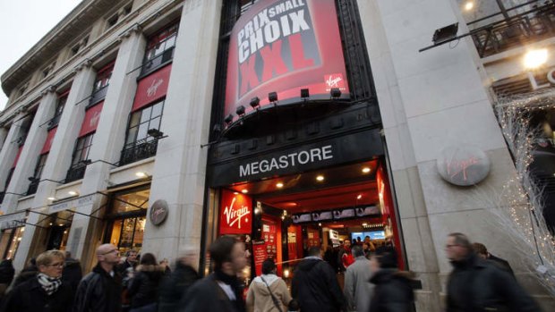 Passers-by walk past the Virgin Megastore on the Champs Elysees avenue.