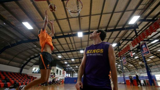 Rarefied air: Sydney Kings star Ben Madgen looks on as GWS rookie Rory Lobb slam dunks.