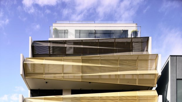 Architects EAT's Cremorne office and cafe boasts a striking facade that features skewed aluminium balustrades in gold or bronze. 