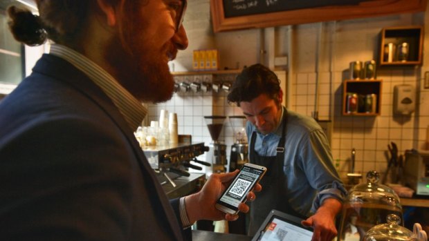 Sam Tate pays for his breakfast at Melbourne's The Little Mule Cafe using bitcoins.