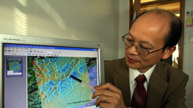 Dr Linlin Ge  with a Japanese satellite image of Sichuan after the earthquake.