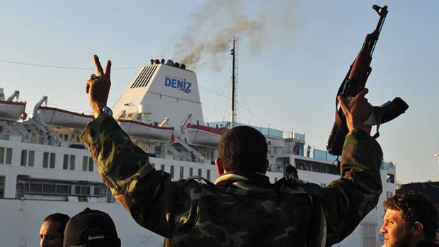 A rebel in Benghazi greets the arrival of a Turkish ship which carried 250 wounded people from the besieged city of Misrata.