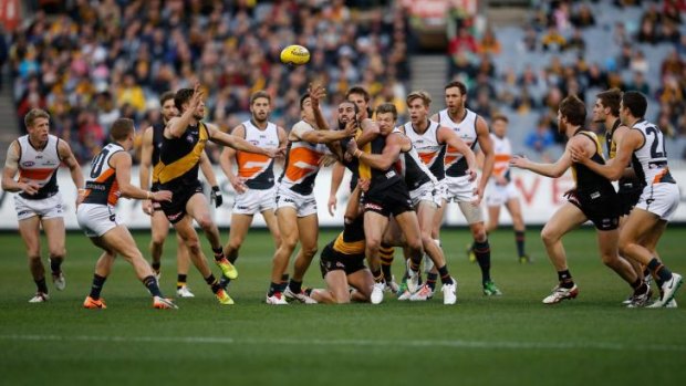 Tiger Bachar Houli handballs from the midst of a pack of players at the MCG on Saturday.