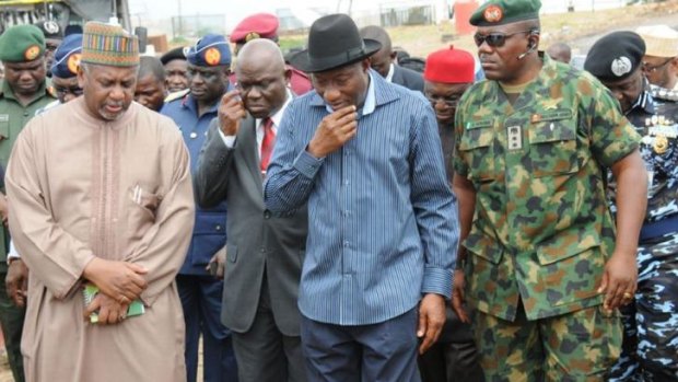 Nigerian President Goodluck Jonathan (centre) arrives at the site of a bus attack in Abuja.