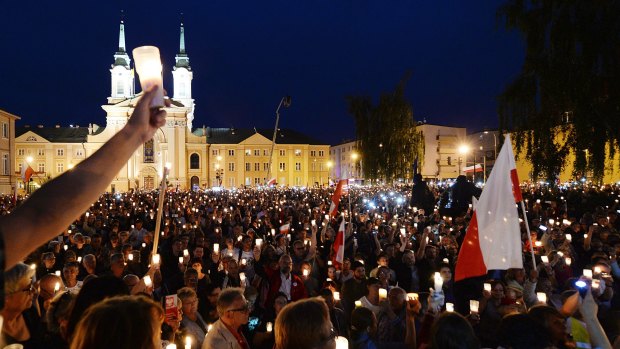 Thousands of anti-government protesters with lit candles gather in front of the Supreme Court in Warsaw. 