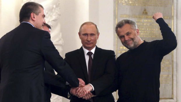 Done deal: Crimean politicians celebrate as they shake the hand of Russian President Vladimir Putin.