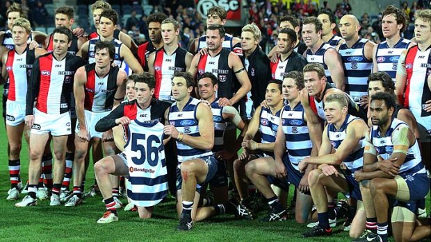 Players from Geelong and St Kilda pose for the Casey Tutungi Appeal after the match.