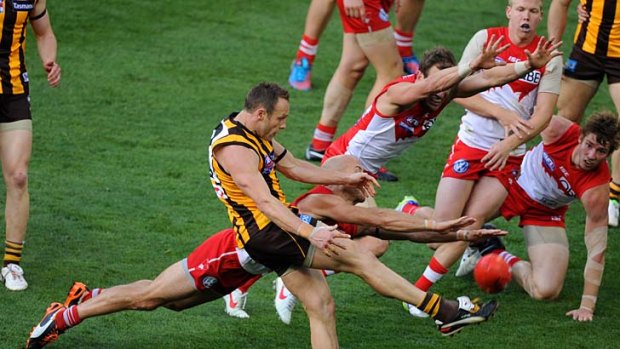 A sea of red and white surrounds Hawthorn's Brad Sewell during the AFL 2012 grand final.