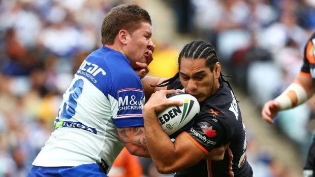 Strong opposition: Bulldogs player Greg Eastwood tackles Martin Taupau of Wests Tigers.