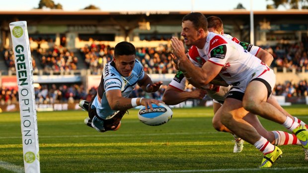 Lovely stuff: Valentine Holmes flies over for a try to Cronulla.