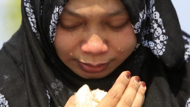 A woman cries at Kuala Lumpur airport as bodies of MH17 passengers return home.