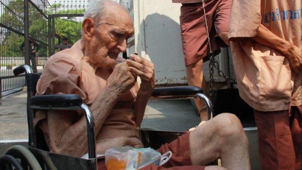 Accused paedophile Karl Joseph Kraus is helped from a prison van in Chiang Mai.