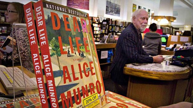 Canadian author Alice Munro's books sit on the bookshelf as her former husband Jim stands at the front counter at Munro's Bookstore in Victoria, British Columbia. The couple were divorced in 1972 and Jim continues to run the shop.