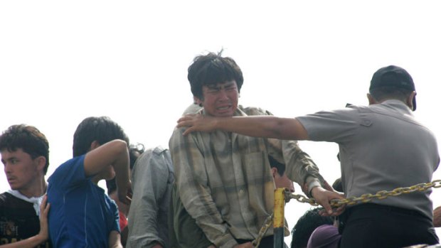 Asylum seekers react as they are removed from their ship by Indonesian authorities in the port city of Merak.