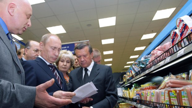 Price check: Vladimir Putin (second from left) examines the meat shelves during a surprise visit to a Perekrestok supermarket in Moscow. 