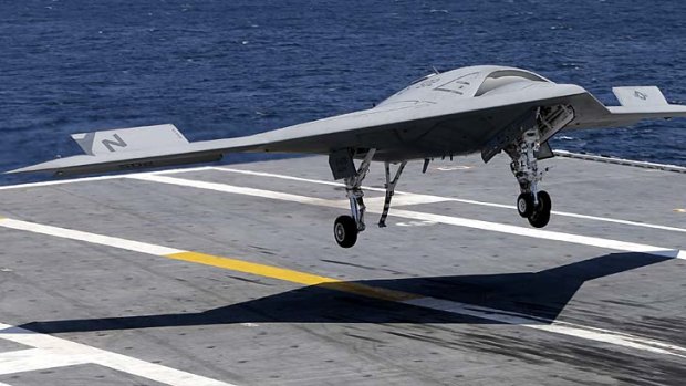 An X-47B drone combat aircraft lands on the deck of the USS George H.W. Bush aircraft carrier.