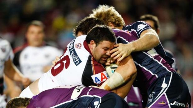 George Rose of the Sea Eagles is tackled by the Storm defence.