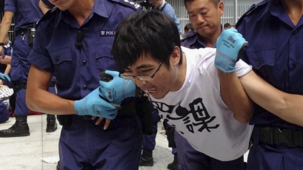 Alex Chow Yong-kang, general secretary of the Hong Kong Federation of Students, is taken away by police during protests.