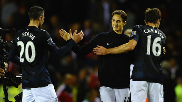 Manchester United's Adnan Januzaj is congratulated on one of his two goals by Robin van Persie and Michael Carrick .