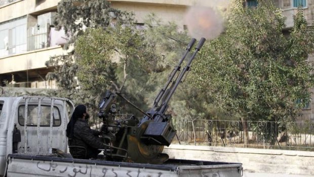 A member of Islamist Syrian rebel group Jabhat al-Nusra fires a weapon on the back of a truck in Aleppo.