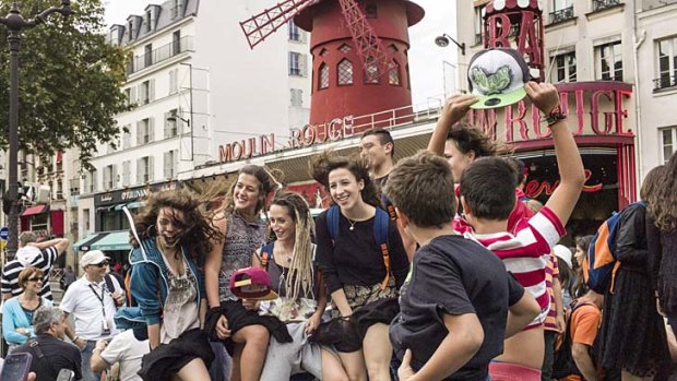 Europeans love it: Italian tourists pose in front of the French cabaret Moulin Rouge in Paris.
