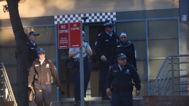 Police at Merrylands Police Station after Thursday night's attack. 