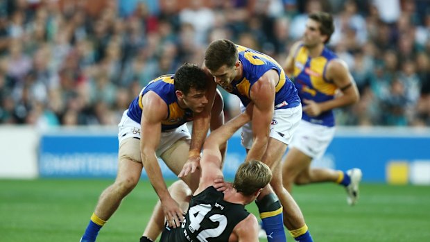 Luke Shuey and Scott Lycett of the Eagles push Tom Jonas during the round nine match.