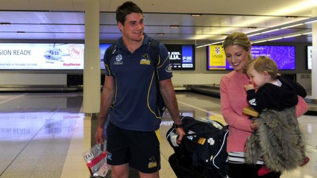 Brumbies captain leaves the airport in July with wife Lauren and their daughter Eleanor.